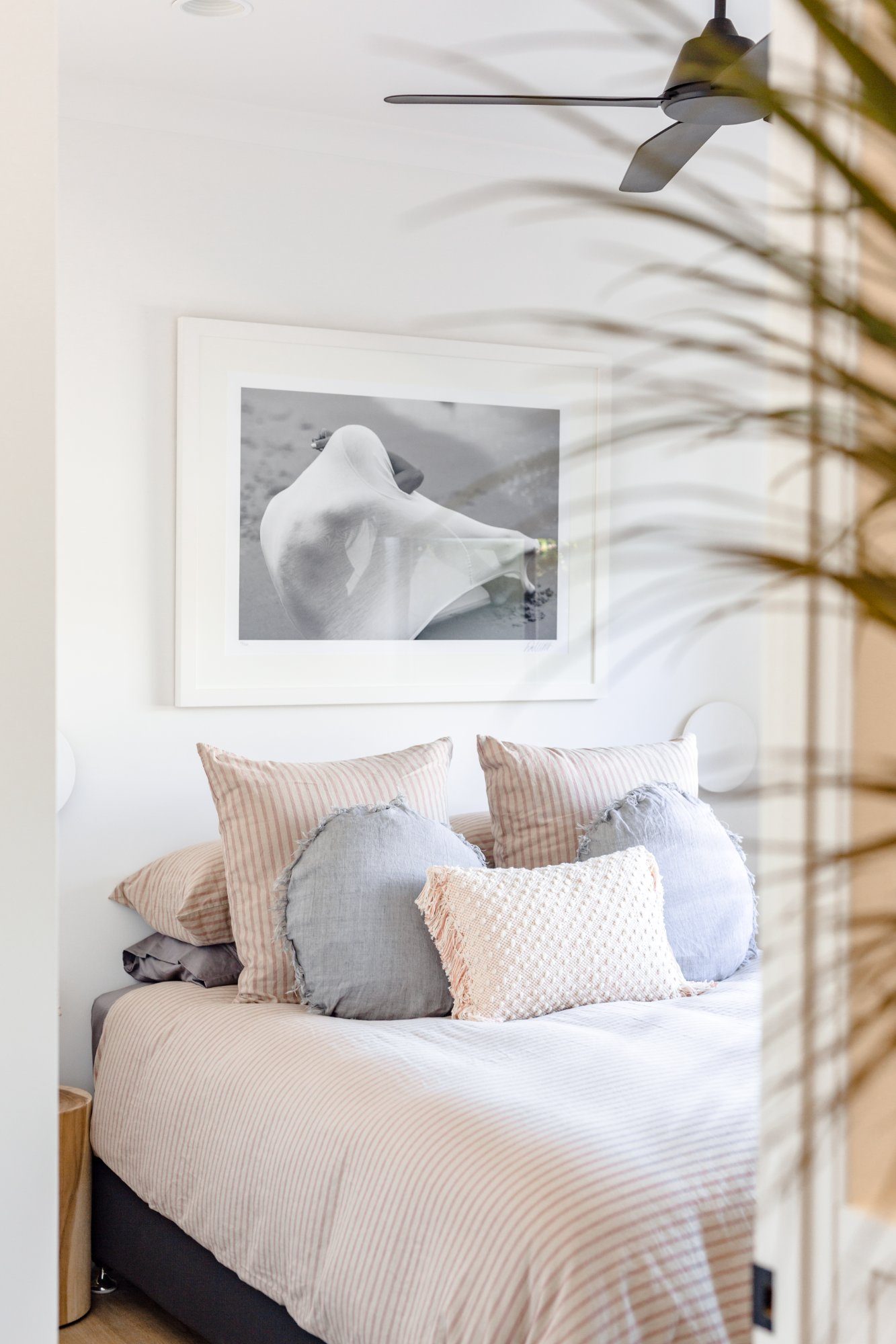 Bedroom 3 with soft pink linen, round cushions and coastal bird artwork