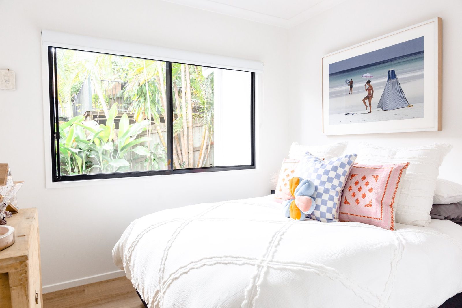 Bedroom 4 with tropical garden view, white bedding and colourful beach cushions