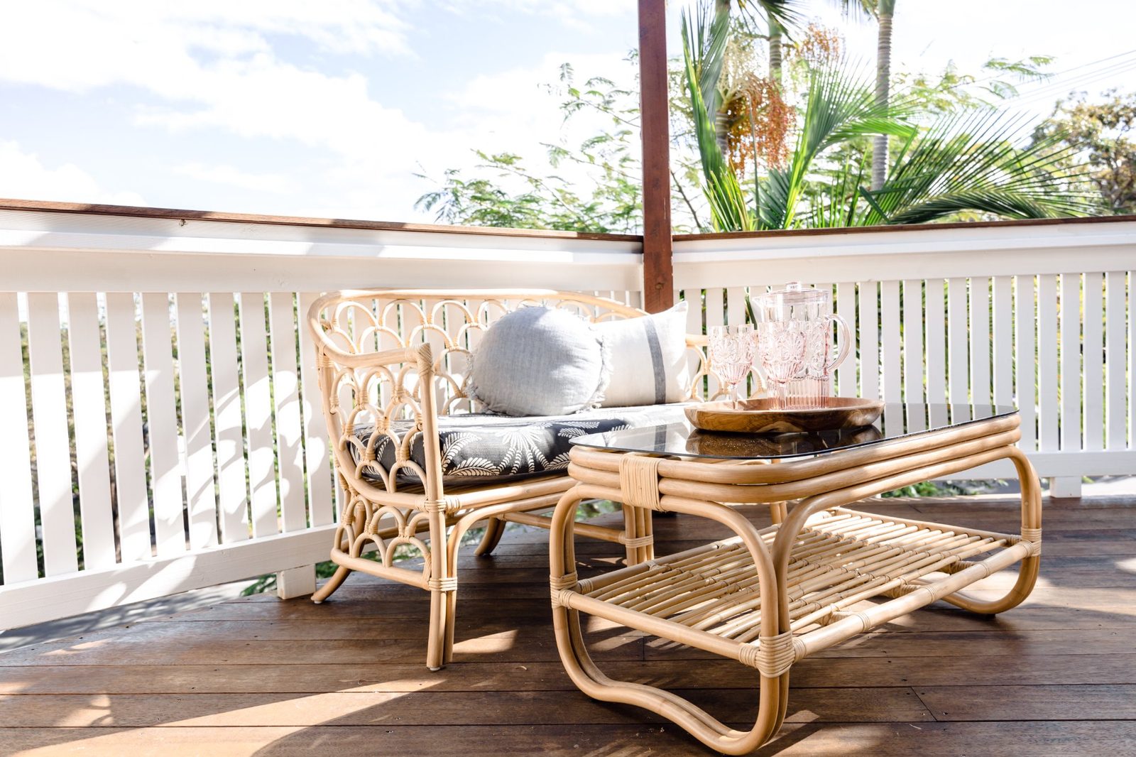 Rattan outdoor lounge setting with tropical garden views at LUXE Noosa